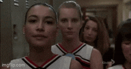 a group of cheerleaders standing next to each other in a hallway .