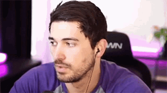 a man with a beard is wearing headphones and looking at the camera .