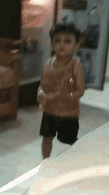 a little boy is standing in front of a refrigerator with the door open