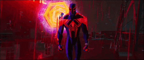 a man in a spiderman suit is standing in a dark room