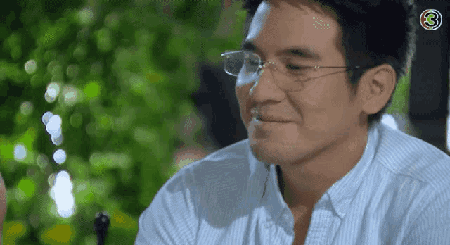 a man wearing glasses is smiling with the number 3 in the corner