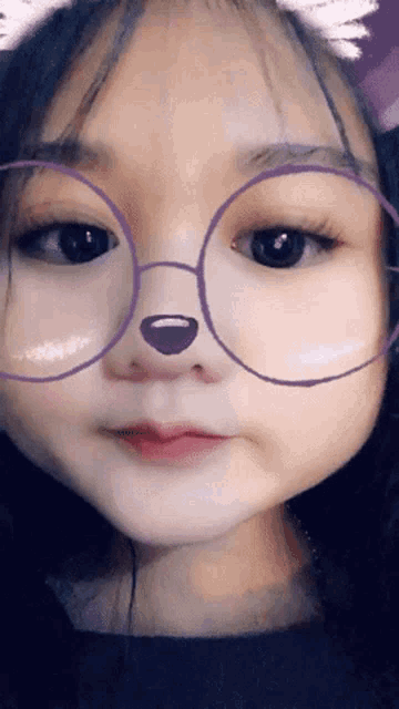 a girl wearing glasses with a purple nose on her face