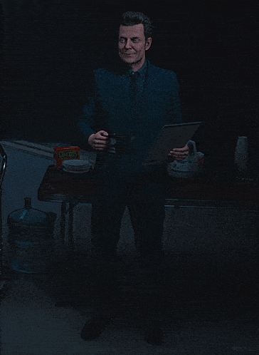 a man stands in front of a table with a box of kellogg 's cereal