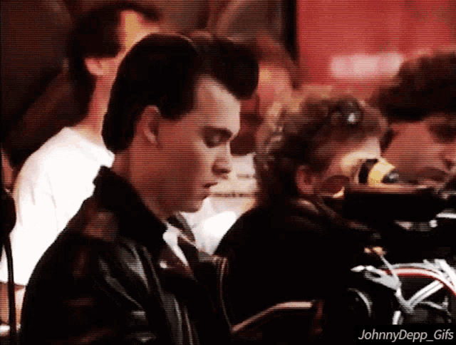 a johnny depp gif shows a man in a black leather jacket