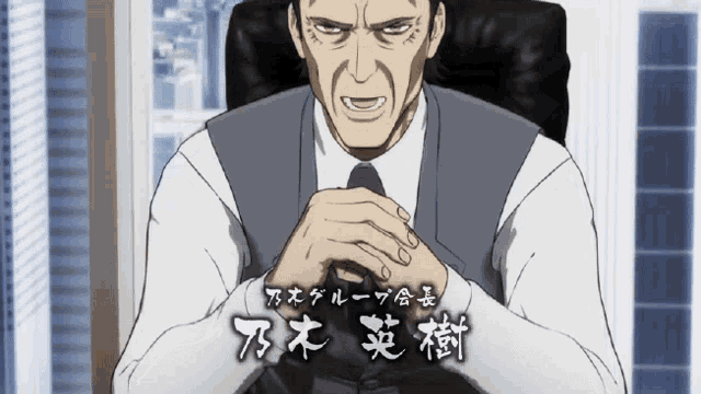 a man in a suit and tie sits in a chair with his hands folded in front of him