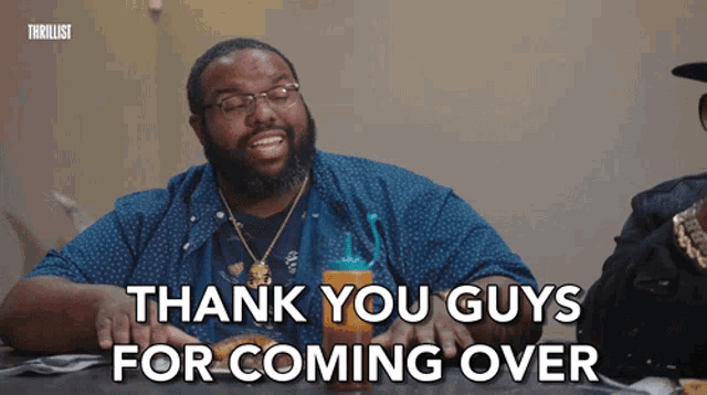 a man sitting at a table with a bottle of sauce and says thank you guys for coming over