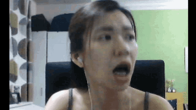 a woman wearing headphones looks surprised with her mouth wide open