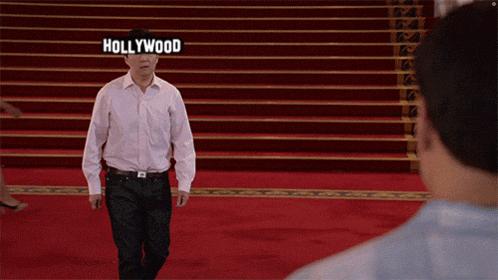 a man walking on a red carpet with the word hollywood written on his face