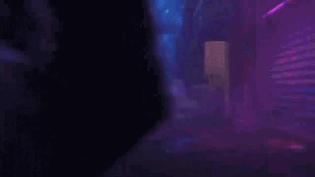 a person is standing in a dark room with a heart shaped light behind them .