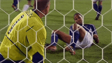 a soccer goalie wearing a yellow jersey with the word volkswagen on the back