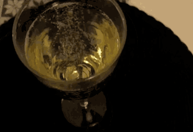 a glass of wine is on a black placemat