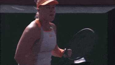 a woman is holding a tennis racquet in her hand