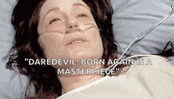 a woman is laying in a hospital bed with an oxygen mask on .