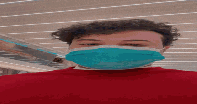 a man wearing a red shirt and a blue mask