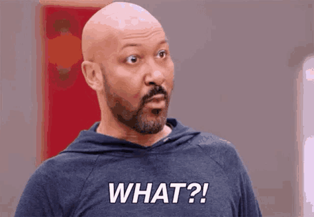 a man with a beard is wearing a hoodie that says `` what ? ''
