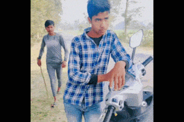 a man in a plaid shirt is standing next to a motorcycle