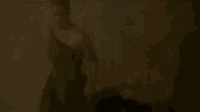 a person is standing in a dark room with smoke coming out of the ceiling .