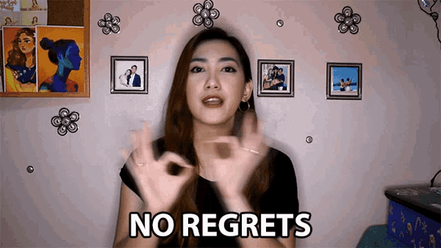 a woman says " no regrets " in front of pictures on a wall