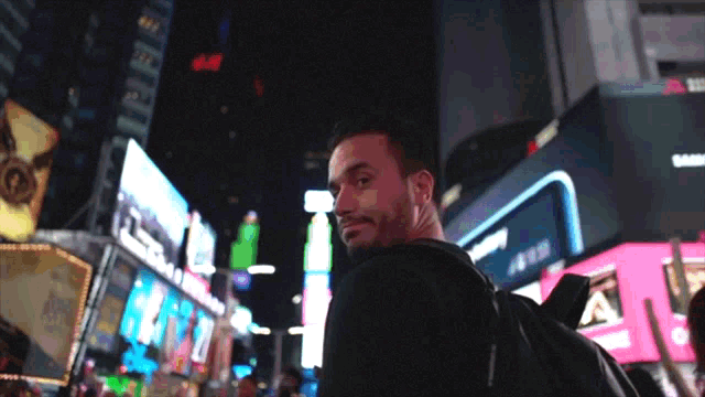 a man in a city at night with a sign that says 4:44