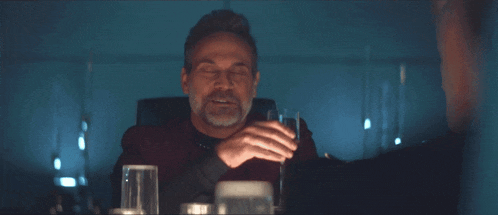 a man sitting at a table with a glass of water in front of him