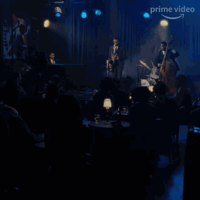a man wearing glasses is playing a saxophone in front of a blue background with the word prime video on it