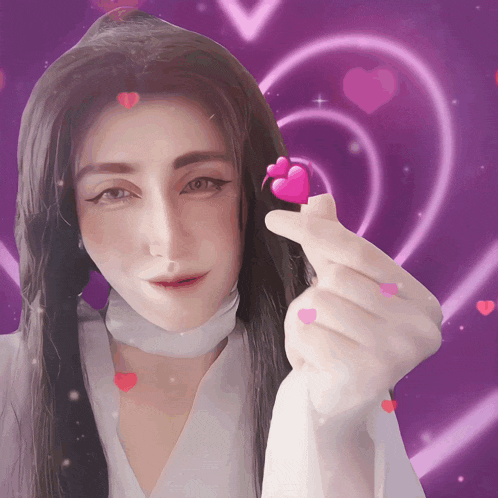 a woman holding a pink heart on her finger