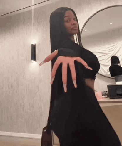 a woman with very long nails holds up her fingers in front of a mirror