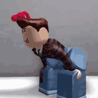 a roblox figure is sitting on a blue block .