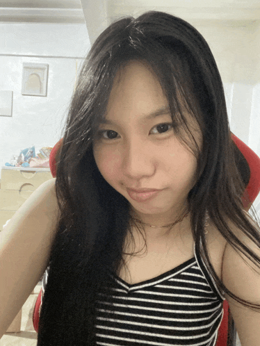 a girl with long black hair is wearing a black and white striped top