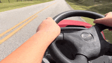 a person is driving a lawn mower on a country road