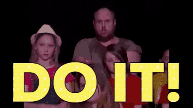 a group of people are standing in front of a sign that says " do it "
