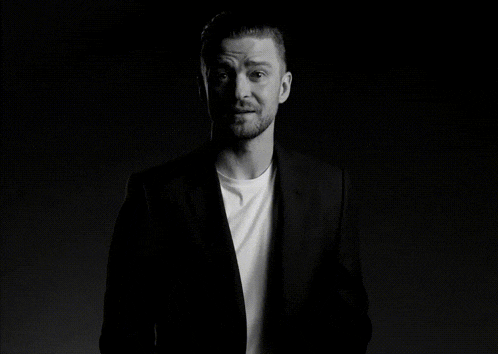 a black and white photo of a man in a suit and white t-shirt
