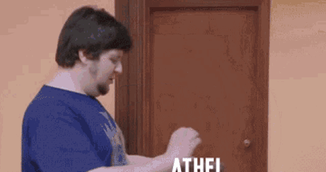 a man in a blue shirt is knocking on a door that says athel