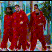 a group of men in red jumpsuits are walking down a hallway