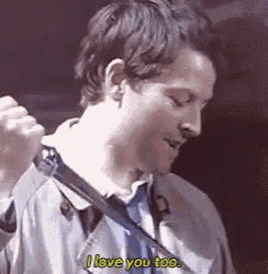 a man in a suit and tie is holding a knife in his hand and saying `` i love you too '' .