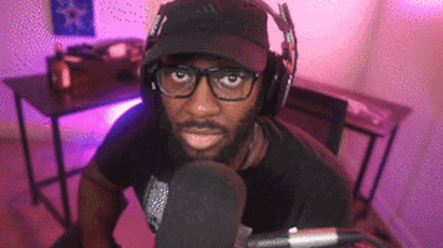 a man wearing headphones and a hat with the adidas logo on it