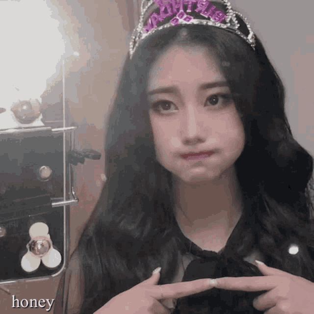 a girl wearing a tiara with the word honey written on it