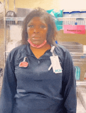 a woman wearing a blue jacket with a name tag that says pca