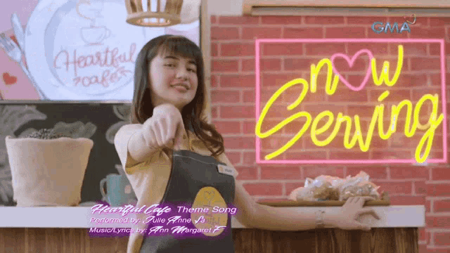 a woman in an apron stands in front of a neon sign that says now serving