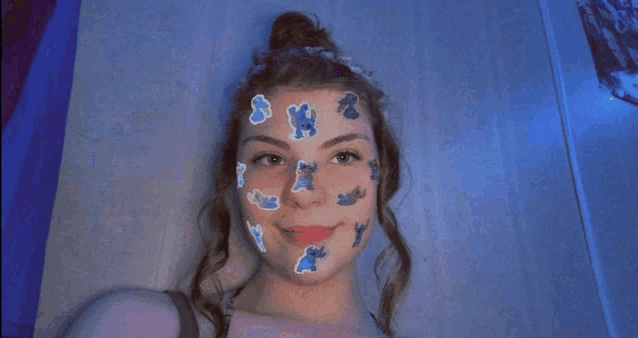 a girl with stickers on her face looks at the camera .