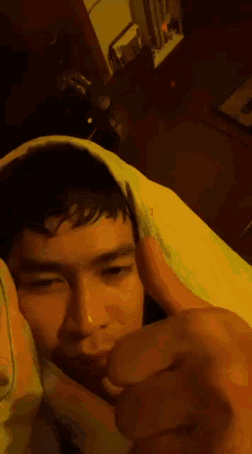 a man is wrapped in a blanket and giving a thumbs up sign