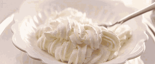 whipped cream in a bowl with a fork in it