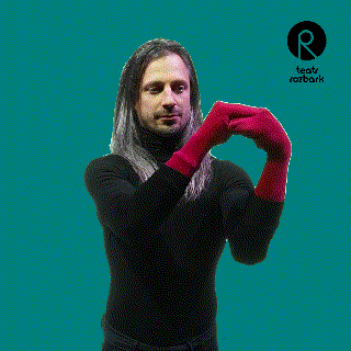 a man wearing a black turtleneck and red gloves is making a heart