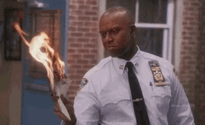 a police officer is holding a burning torch .