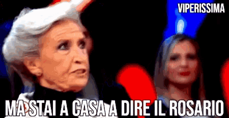 a woman with gray hair says " ma stai a casa a dire il rosario " in front of two other women