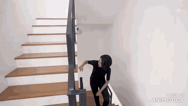 a woman is walking down a set of wooden stairs made in animatica