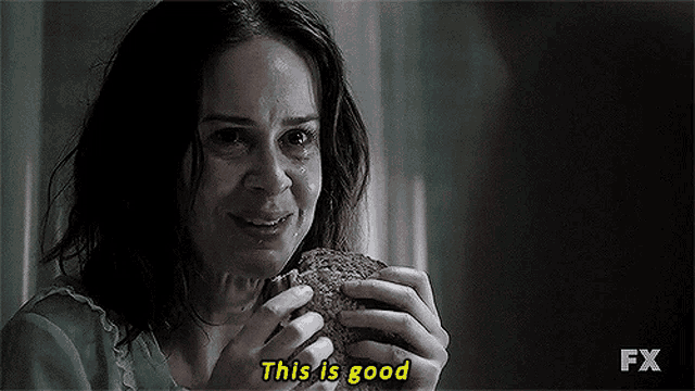 a woman is holding a sandwich in her hands and crying .