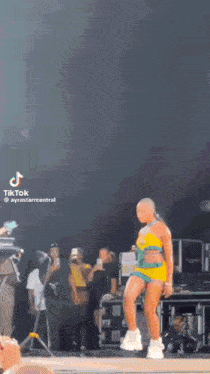 a woman is dancing on a stage at a concert .