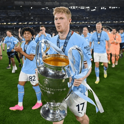 a soccer player holding a trophy with the number 17 on his shorts