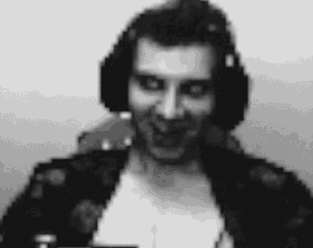a black and white photo of a man wearing headphones and making a funny face .